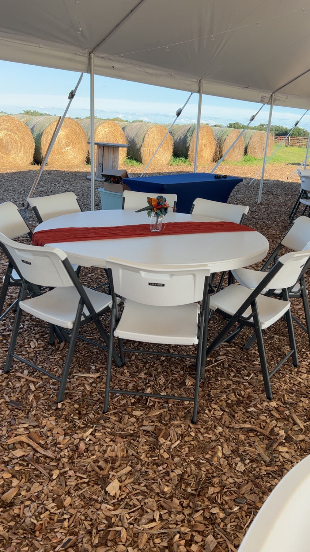 Round table and chair setup under an event tent