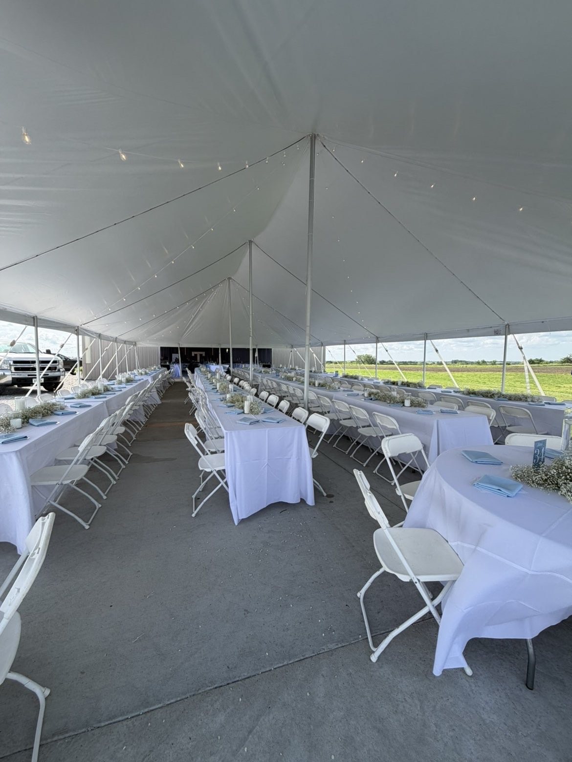 Large wedding reception setup under a tent