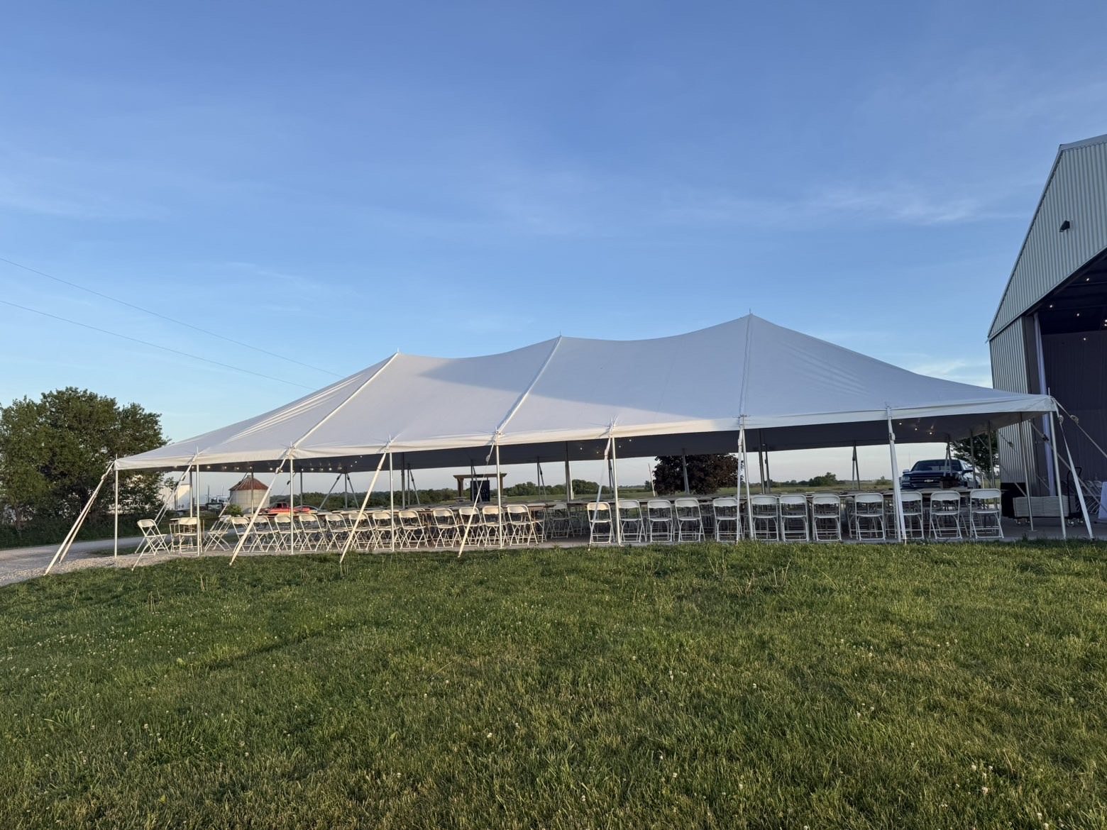 Large event tent with seating beside a venue