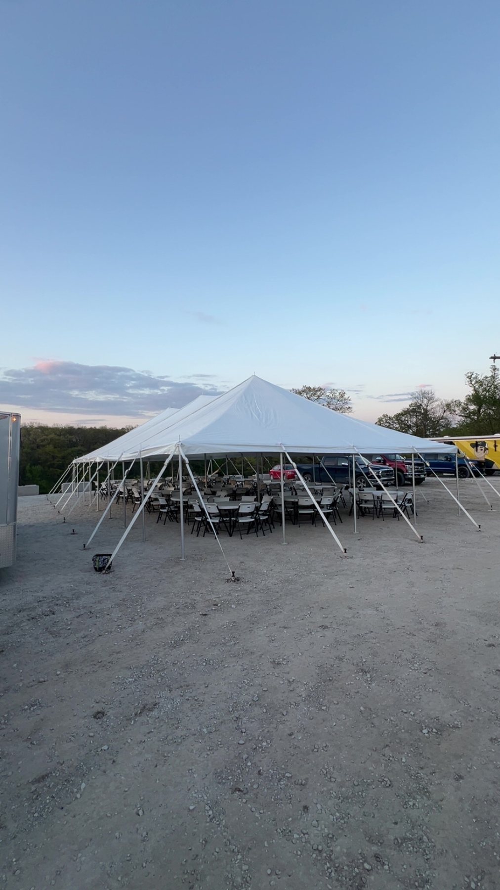 Event tent setup with tables and chairs on gravel
