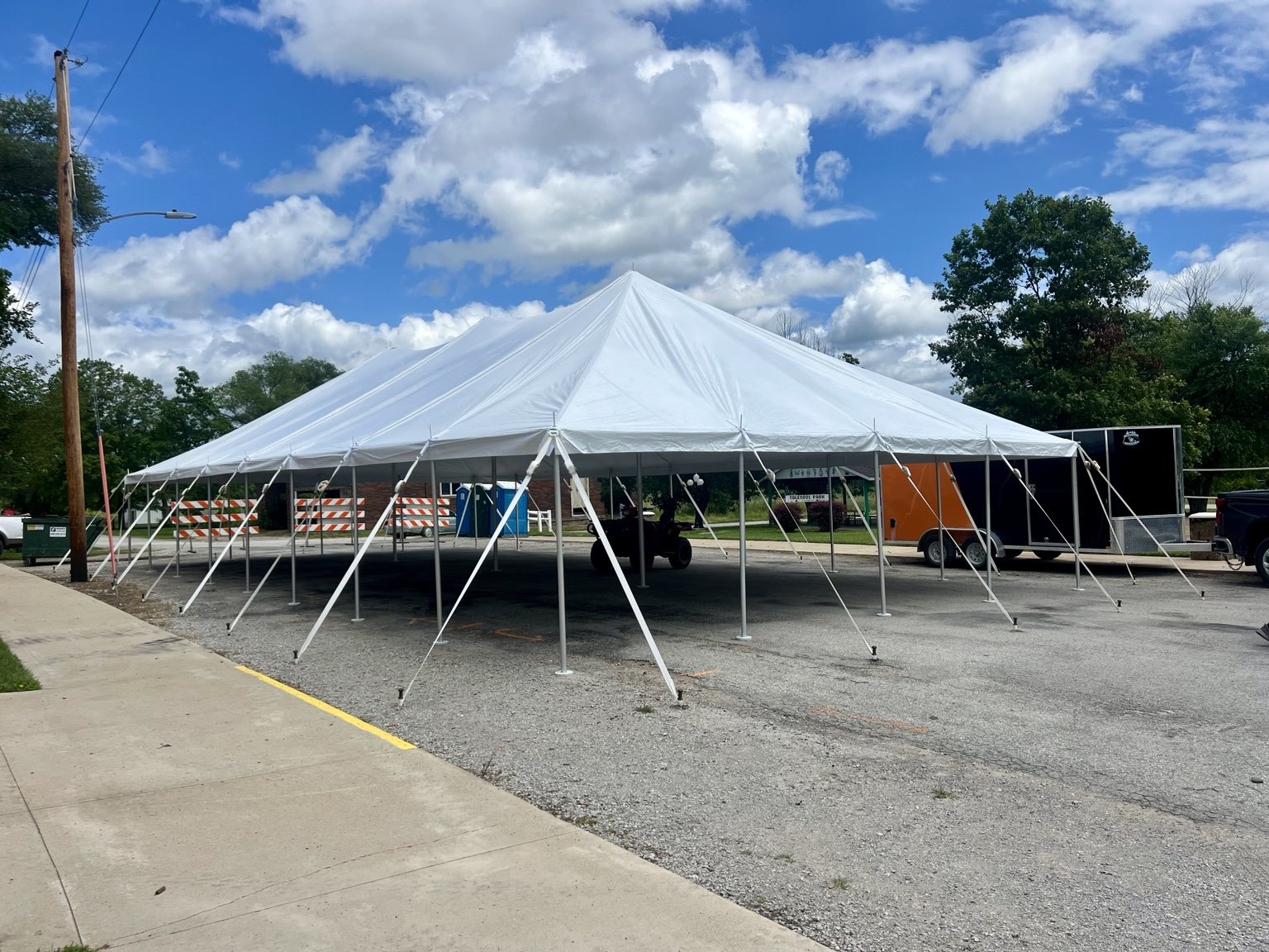 Large event tent setup under blue skies